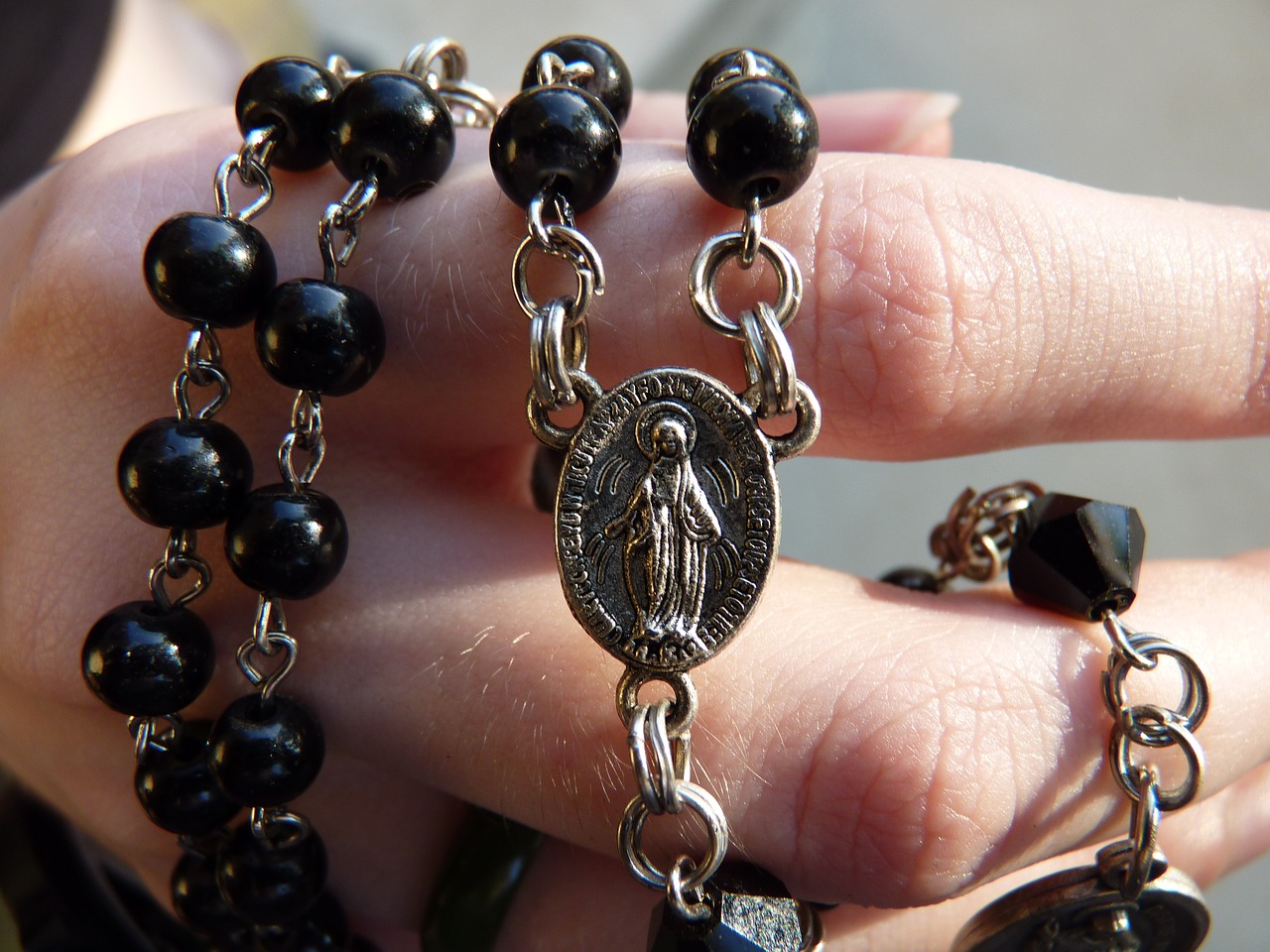 Rosary entwined on hand